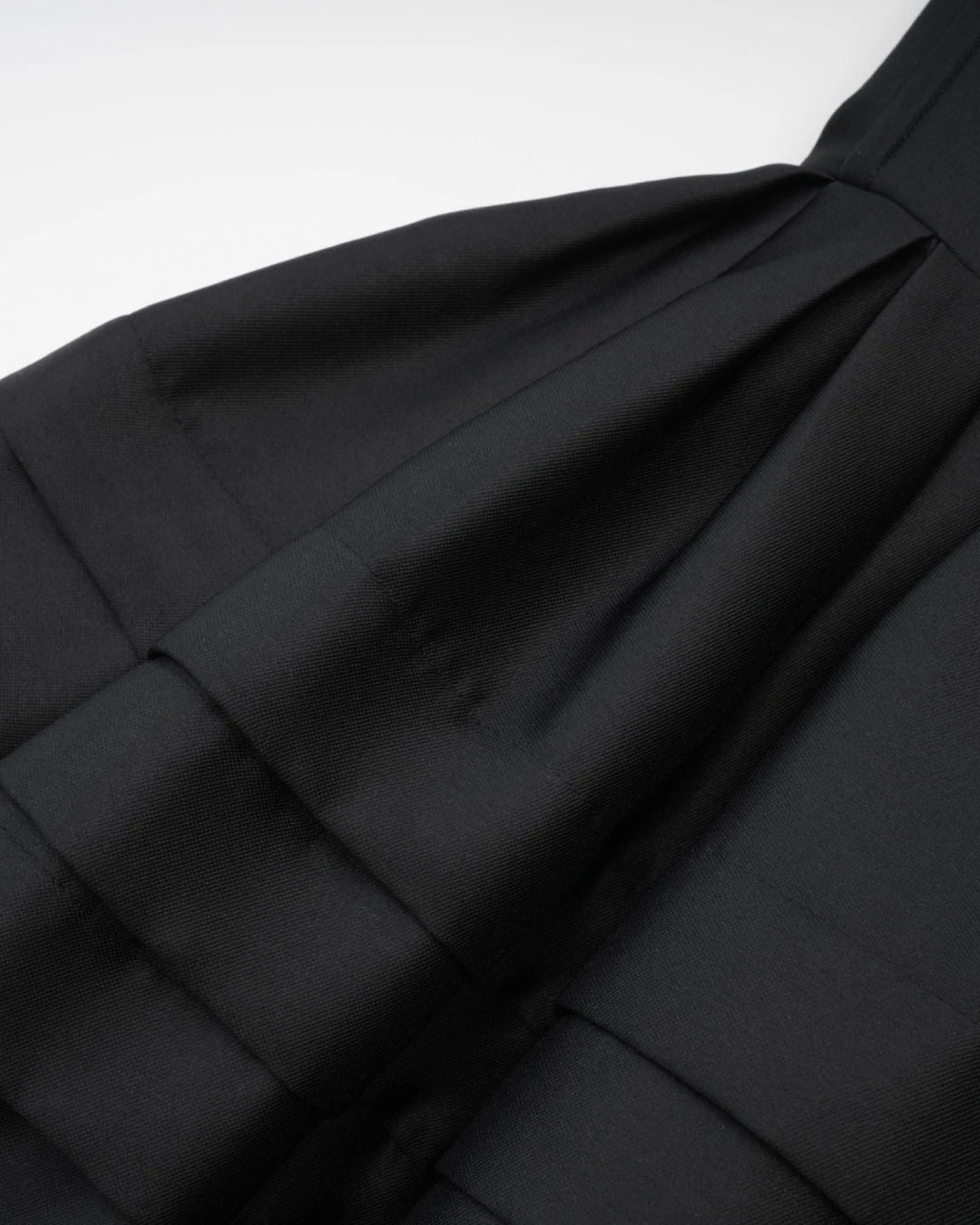 Close-up of black fabric with folds of women's midi dress in black, perfct for old money style