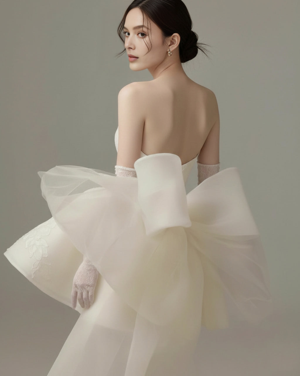 Bridal model wearing Allison Mini Dress in off white wiAllison Ivory Mini Dress, White Mini Dress, bridal mini dress​, mini bridal dress​, white bridal mini dresses​th bow-tie tulle veil at the back