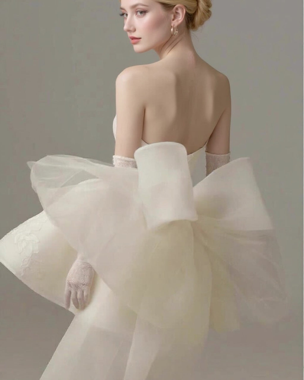 Bridal model wearing Allison Mini Dress in off white with bow-tie tulle veil at the back