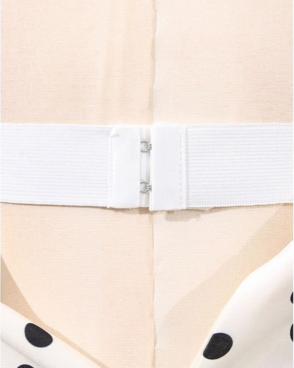 Close-up of a white waistband of lucia polka dot midi dress