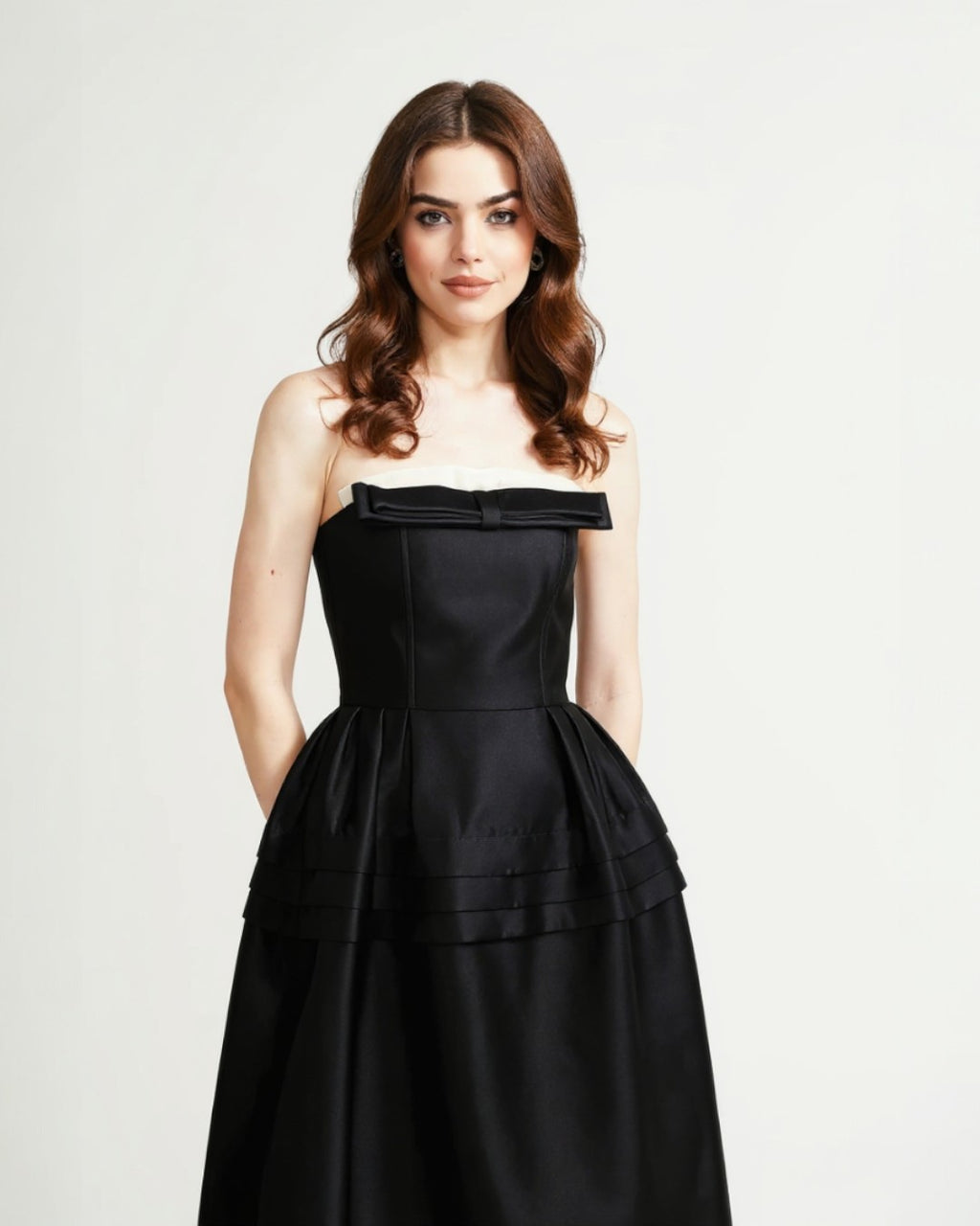 Woman wearing a black strapless dress that captures the old money style.