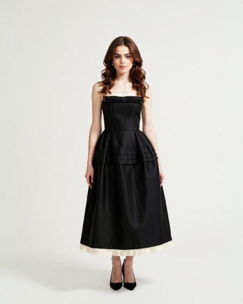 Woman wearing a black strapless dress with a white hem